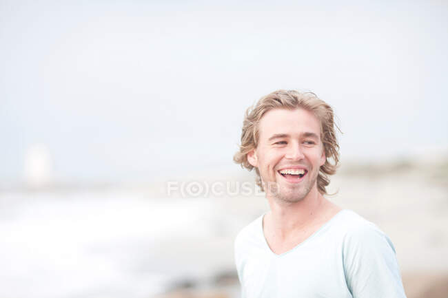 Uomo godendo la brezza sulla spiaggia — Foto stock