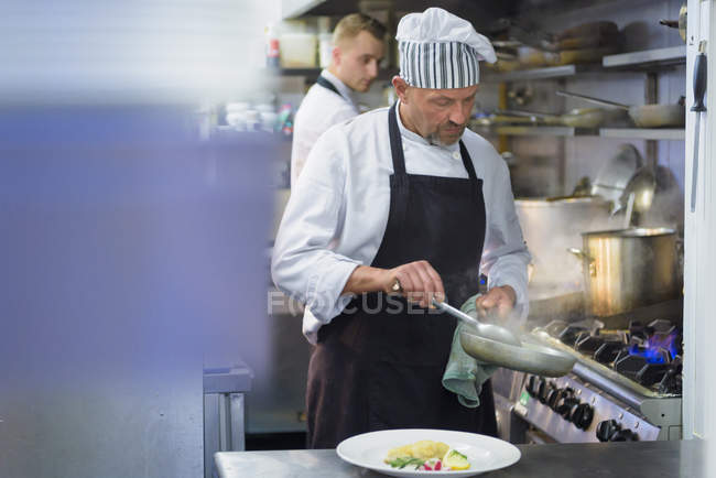 Chef cooking food in traditional Italian restaurant kitchen — Stock Photo