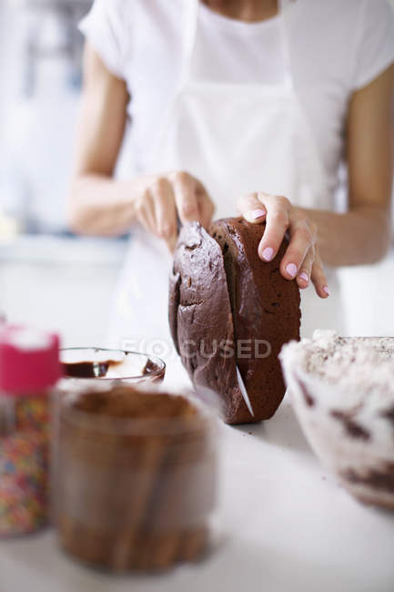 Woman slicing top of cake — Stock Photo