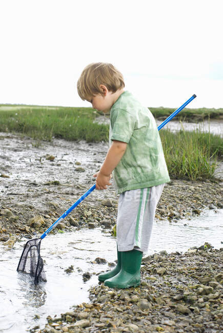 Giovane ragazzo pesca con rete — Foto stock