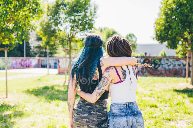 Rear view of two young women in urban park — Stock Photo