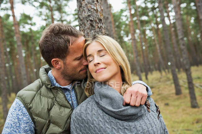 Meio adulto casal abraçando na floresta — Fotografia de Stock