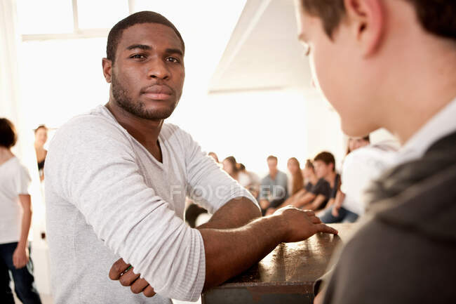 Group of friends at house party, young man looking at camera — Stock Photo