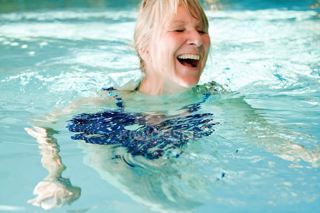 Ältere Frau schwimmt im Pool — Stockfoto