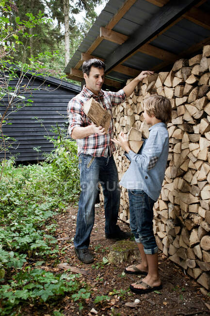 Vater und Sohn holen Brennholz ins Freie — Stockfoto