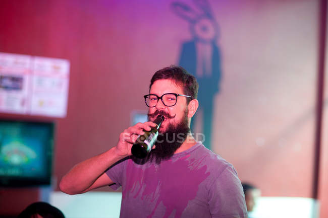 Hombre bebiendo cerveza en el bar - foto de stock