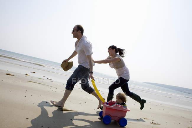 Семья играет вместе на пляже — стоковое фото