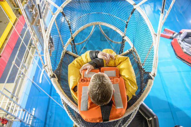 Offshore oil worker training in net escape simulation at training pool facility — Stock Photo