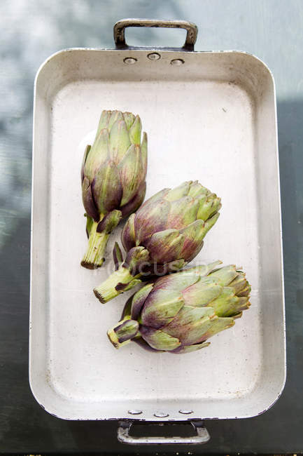Top view of fresh artichokes in baking tray — Stock Photo