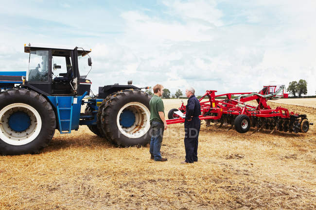 Farmers talking in crop field — Stock Photo