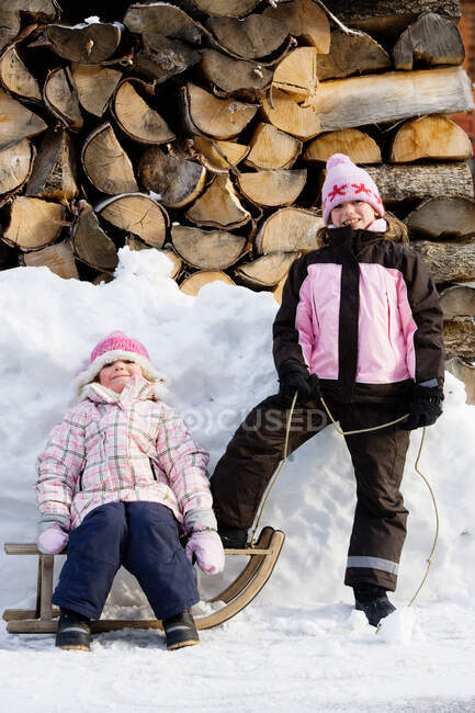 Raparigas posando com trenó na neve — Fotografia de Stock