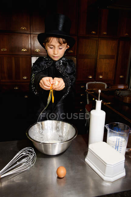 Boy magician cooking in kitchen — Stock Photo