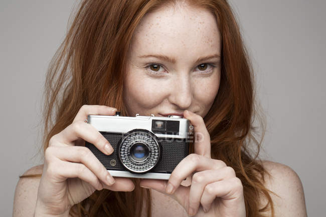 Portrait of young woman, taking photograph — Stock Photo