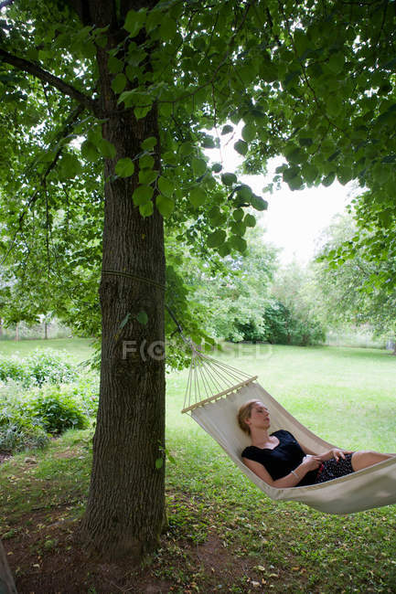 Женщина отдыхает в гамаке на открытом воздухе — стоковое фото