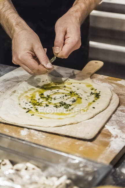 Koch bereitet Pizzabrot in gewerblicher Küche zu — Stockfoto