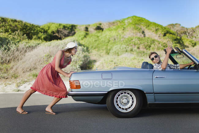 Donna spingendo auto come fidanzato manzi — Foto stock