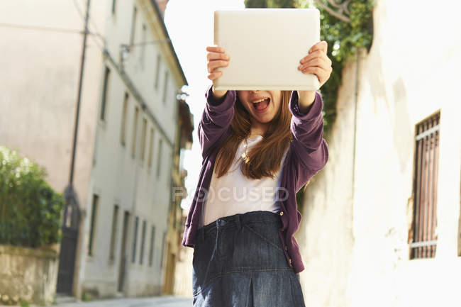 Chica fotografiando con tableta digital en la calle, Provincia de Venecia, Italia - foto de stock