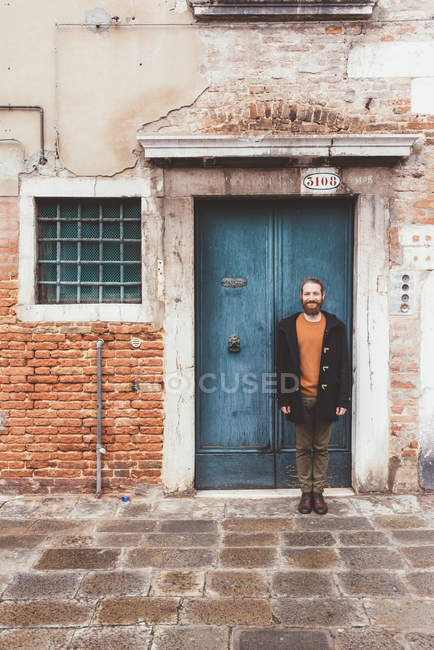 Porträt eines bärtigen erwachsenen Mannes, der vor einer alten Tür steht, Venedig, Italien — Stockfoto