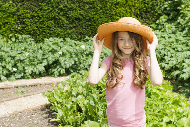 Mädchen trägt Strohhut im Garten — Stockfoto