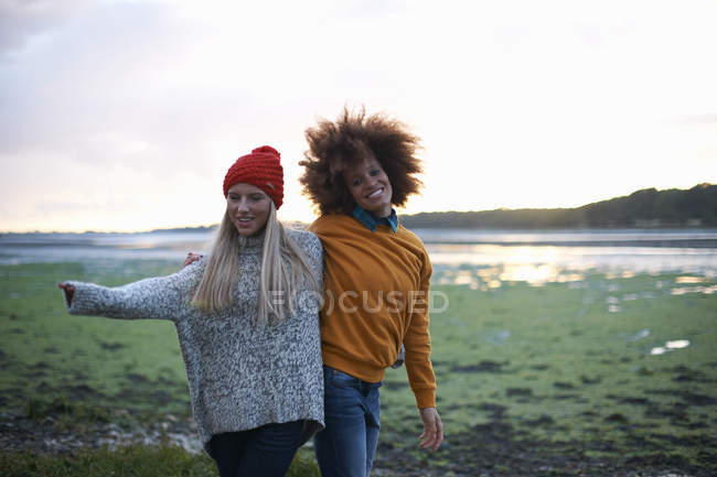 Retrato de duas jovens mulheres por mar ao pôr do sol — Fotografia de Stock