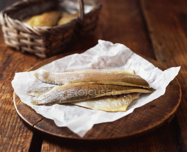 Sea bass fillets on wooden chopping board — Stock Photo