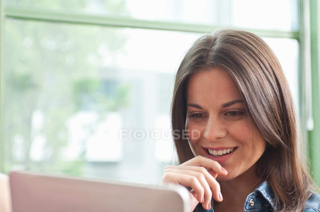 Молода жінка дивиться на цифровий планшет — стокове фото