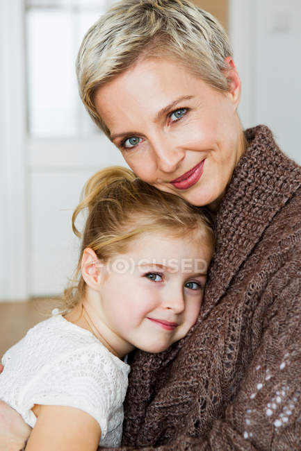 Усміхнена мати і дочка обіймаються — стокове фото