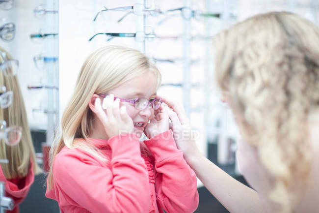 Young girl trying on eyeglasses — Stock Photo