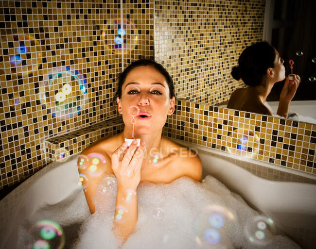 Mulher no banho soprando bolhas — Fotografia de Stock