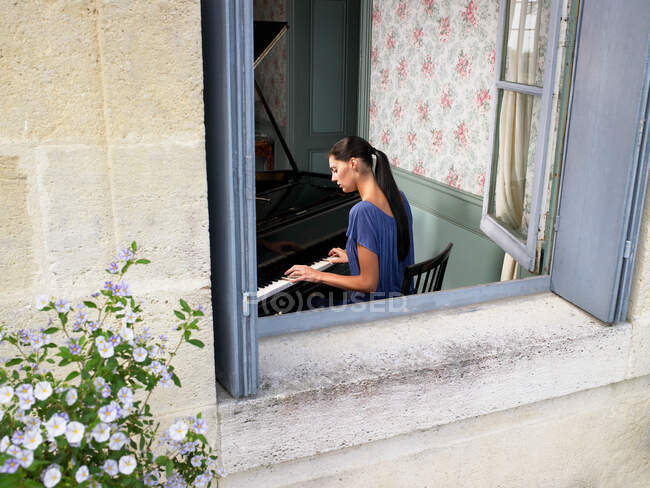 Vista posteriore di Donna che suona il pianoforte — Foto stock
