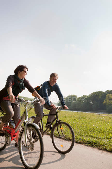 Couple à vélo sur la route rurale — Photo de stock