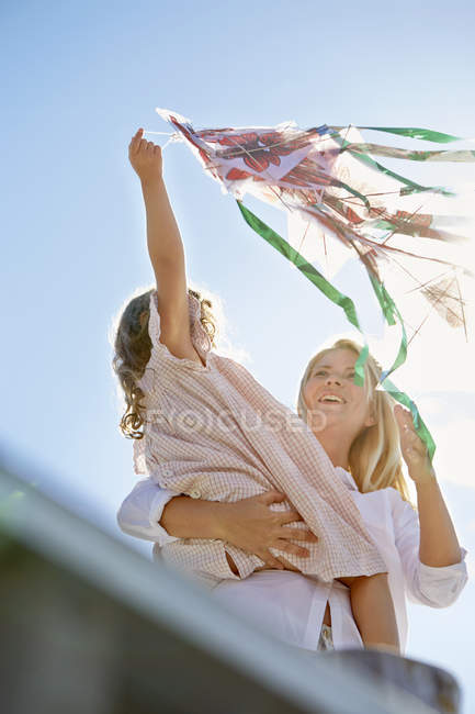 Мати і дочка грають з повітряним змієм — стокове фото