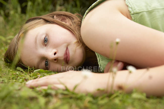 Close up retrato de menina deitada na grama do jardim — Fotografia de Stock