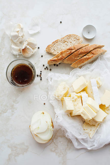 Sliced bread with butter and garlic on table, top view — Stock Photo