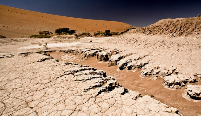 Vista panorámica de la tierra agrietada en el paisaje del desierto - foto de stock