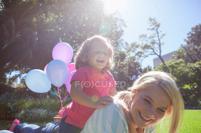 Madre con figlia sdraiata in giardino — Foto stock