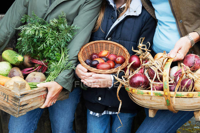 Imagen recortada de Familia sosteniendo verduras - foto de stock
