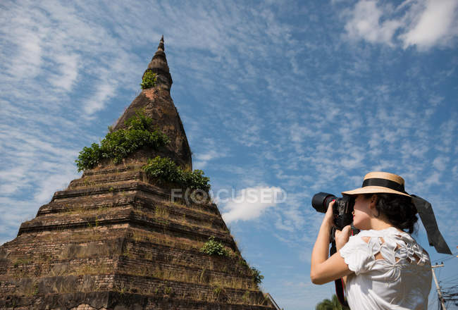 Mujer tomando fotografías en That Dam, Vientiane, Laos - foto de stock