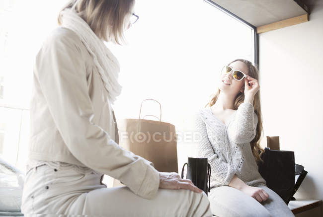Старша жінка і онука намагаються на сонцезахисних окулярах в магазині — стокове фото
