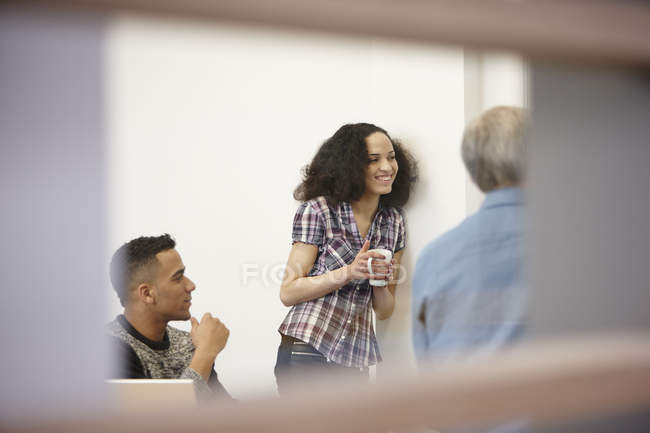 Businesswoman and men drinking coffee in office meeting — Stock Photo
