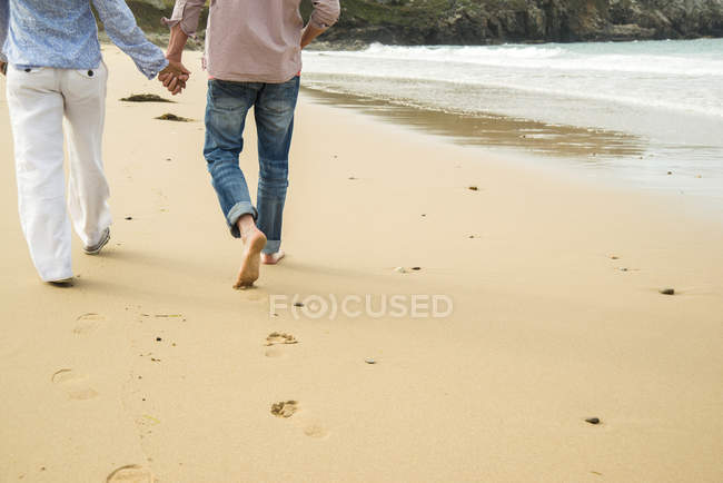 Schnappschuss eines reifen Paares, das sich beim Strandspaziergang an den Händen hält, Camaret-sur-mer, Bretagne, Frankreich — Stockfoto