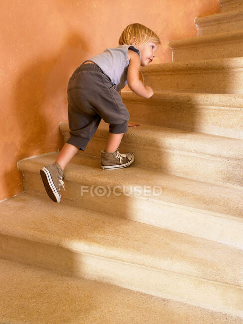Little girl climbing up the stairs — Stock Photo