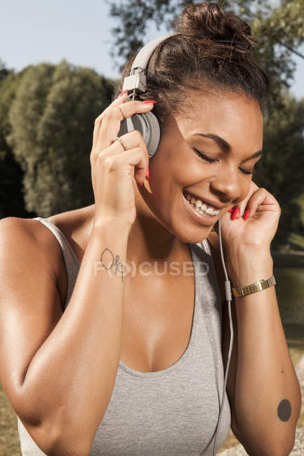 Mujer joven disfrutando de la música en sus auriculares - foto de stock