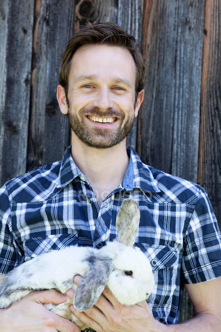 Homem segurando coelho ao ar livre — Fotografia de Stock