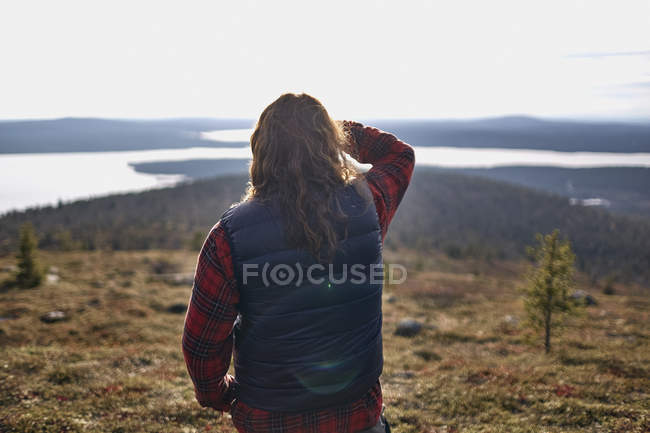 Vista posteriore dell'escursionista che si affaccia sul lago, Keimiotunturi, Lapponia, Finlandia — Foto stock