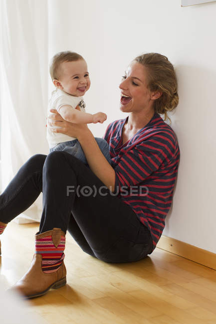 Madre jugando con bebé niño - foto de stock