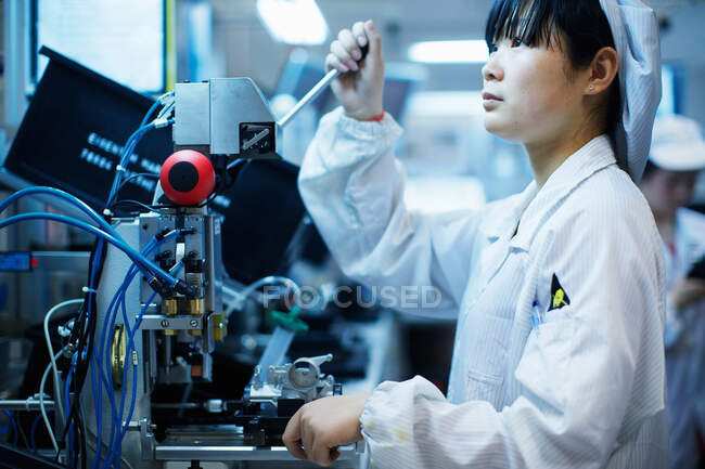 Trabajador en la fábrica de fabricación de piezas pequeñas en China - foto de stock