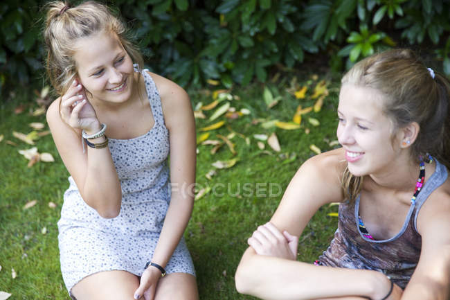 Two teenage girls sitting in garden — Stock Photo