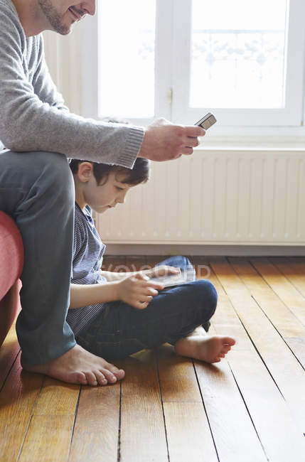 Father and son spending time in living room on wooden floor — Stock Photo
