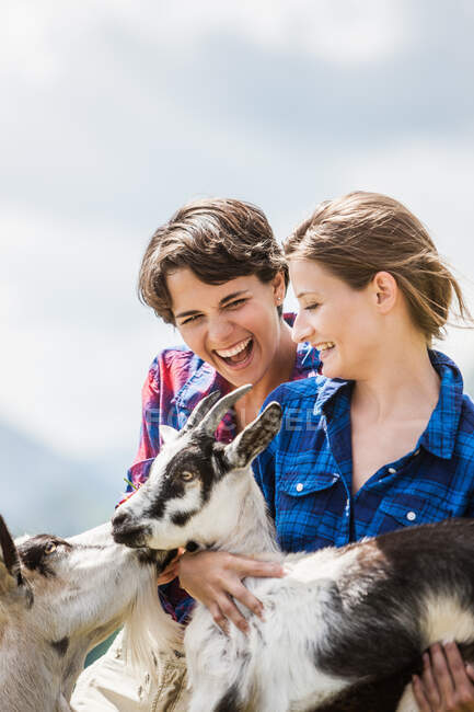 Two female friends with goats — Stock Photo